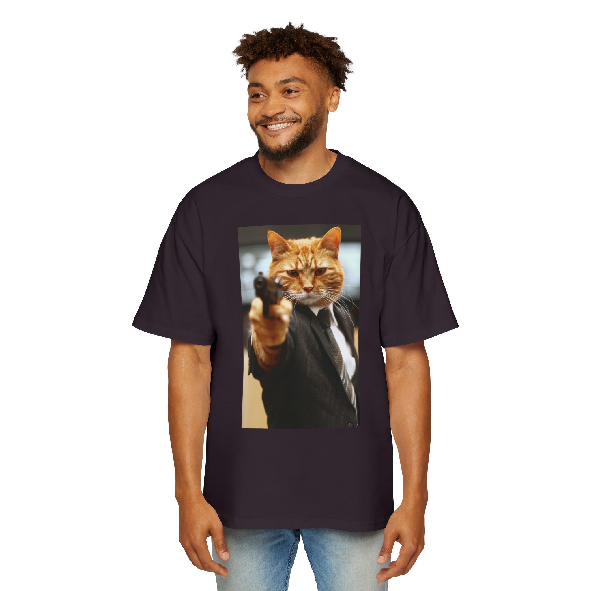 The image showcases a stylish men's heavy oversized tee in a dark color, enhancing the vivid Hitman Cat graphic. The tee's relaxed fit is visible, promising comfort and style. The design is eye-catching and humorous, perfect for those who like their fashion to come with a story.