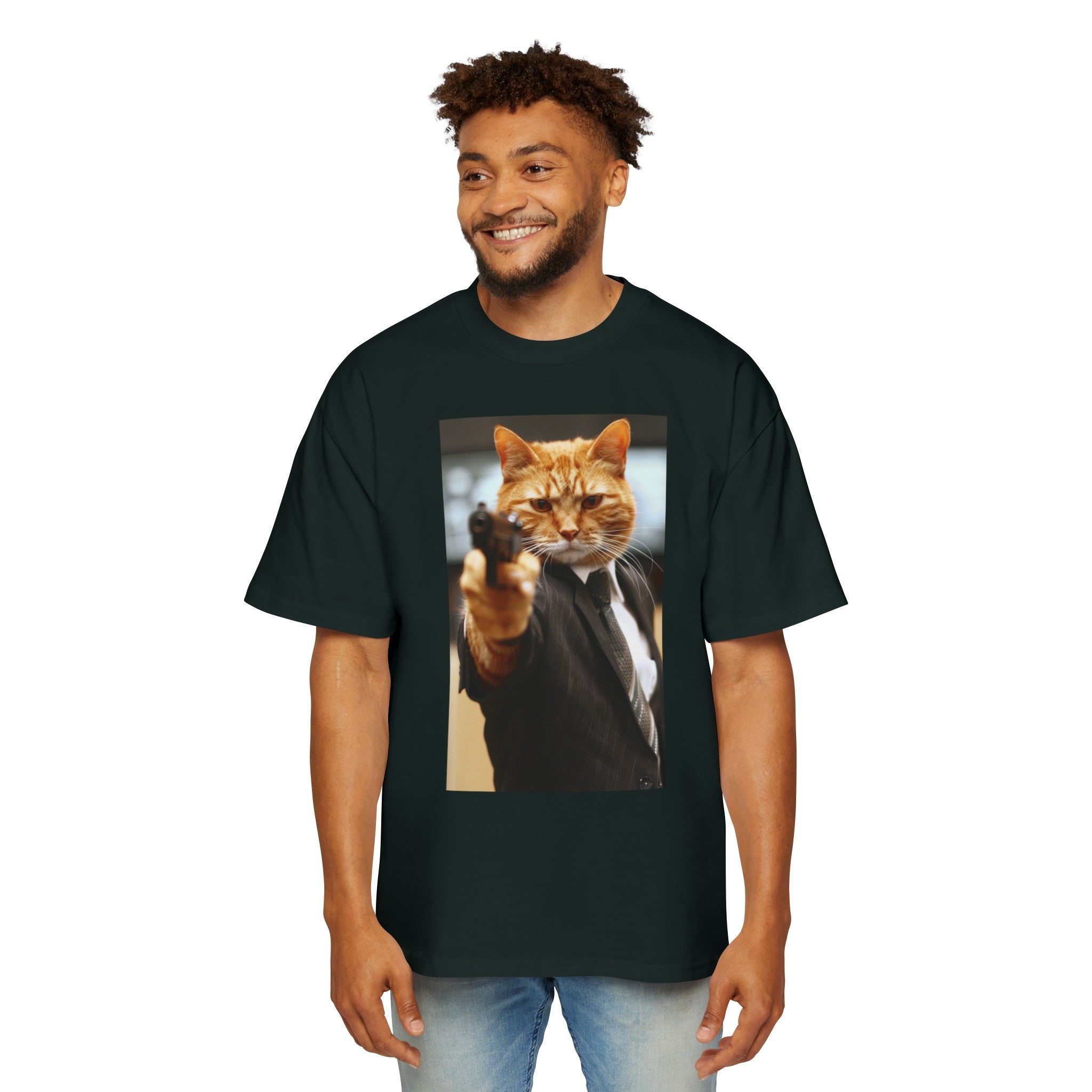 The image showcases a stylish men's heavy oversized tee in a dark color, enhancing the vivid Hitman Cat graphic. The tee's relaxed fit is visible, promising comfort and style. The design is eye-catching and humorous, perfect for those who like their fashion to come with a story.