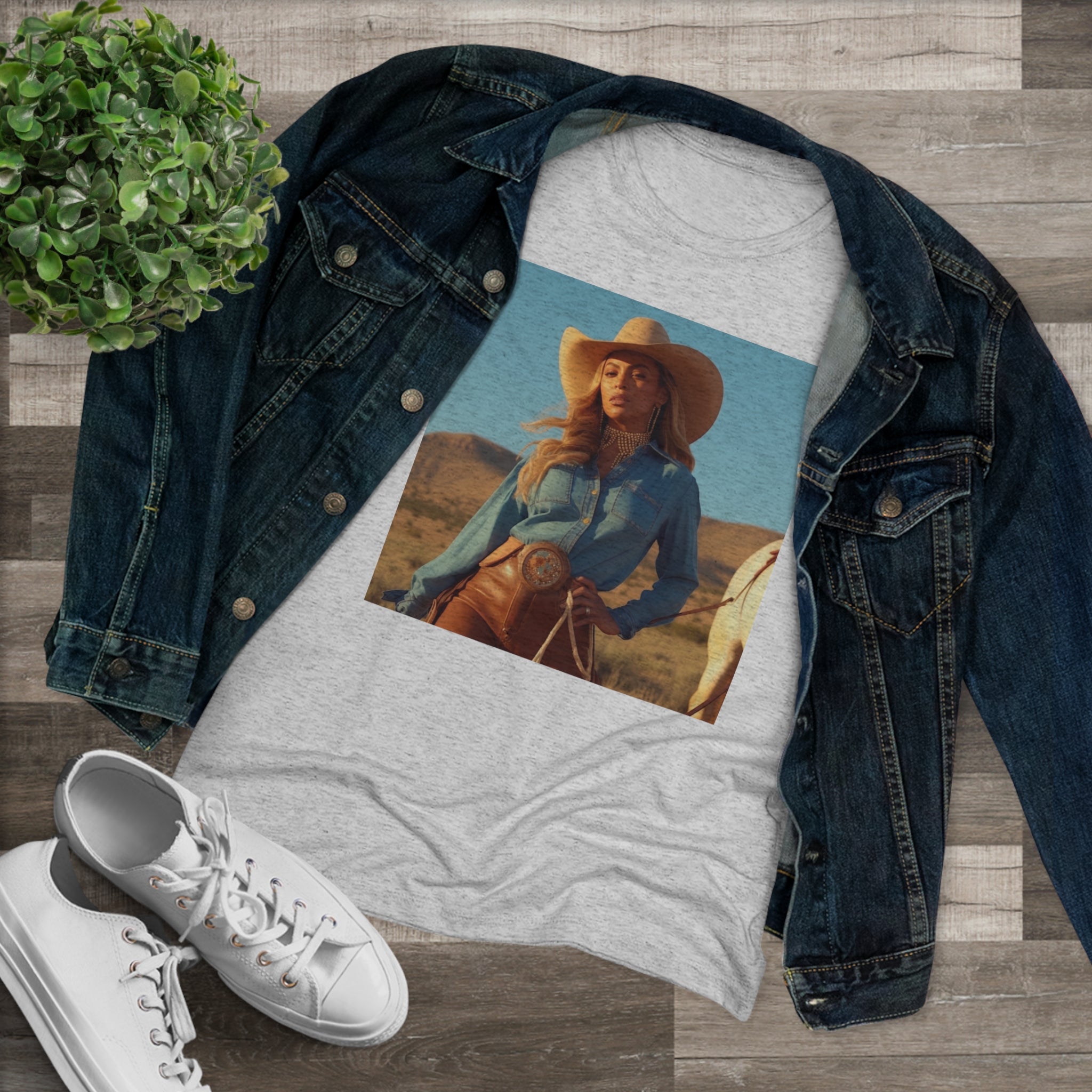 This image features a stylish women's tri-blend tee with a unique design inspired by Beyoncé’s influence on country music. The tee showcases a soft, comfortable fabric in a flattering fit, adorned with artwork that celebrates the crossover charm of country and pop music by the beloved music icon.