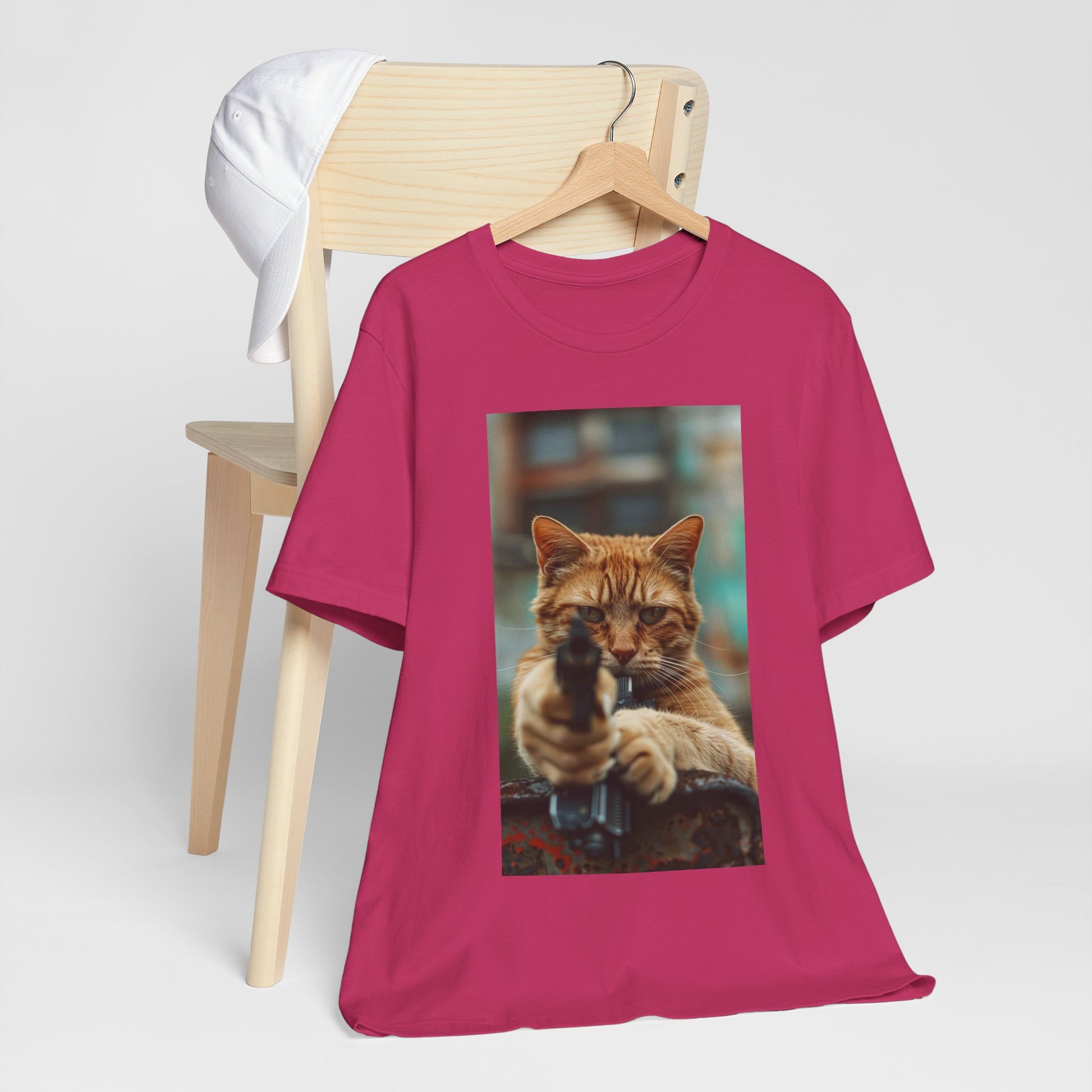 The image displays a sleek women's jersey short sleeve t-shirt, featuring a detailed and humorous image of a cat in role of hitman. The t-shirt is modeled to showcase its flattering fit and soft fabric, highlighting how fashion can meet fun and functionality