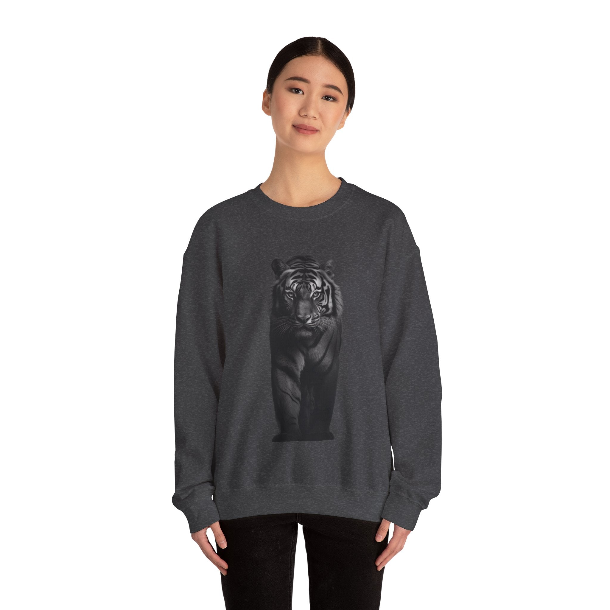 The image features a unisex Heavy Blend™ crewneck sweatshirt adorned with a vibrant, high-definition design of a tiger's intense stare. The sweatshirt is shown in a rich, appealing color, highlighting the detailed artwork and the cozy, relaxed fit of the garment, designed to inspire and comfort its wearer.