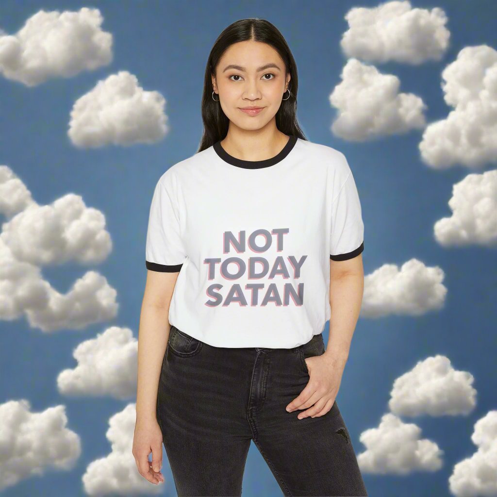 The image showcases a unisex cotton ringer t-shirt with the phrase "Not Today, Satan" boldly printed on the chest. Contrasting collar and sleeve trims enhance its retro charm, and the soft, breathable fabric ensures comfort.