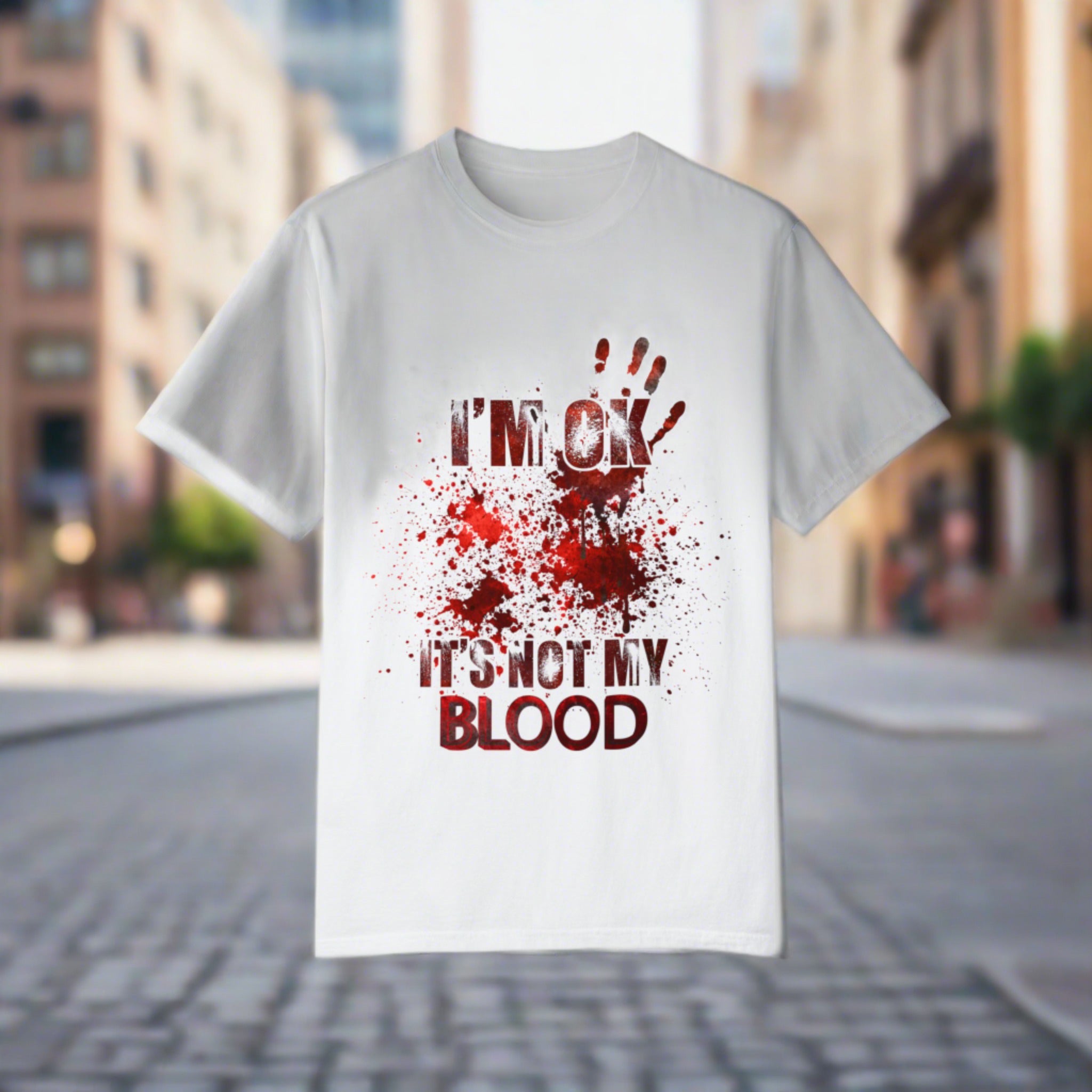 The image features a unisex garment-dyed t-shirt displaying a humorous scene of a zombie fight with the text "I'm OK..." splashed across in bold, eye-catching letters. The design emphasizes both the comedy and the horror elements, perfectly balancing the two for fans of both genres. The shirt's quality fabric and faded color palette enhance the vintage, laid-back vibe, making it an essential addition to any casual wardrobe.